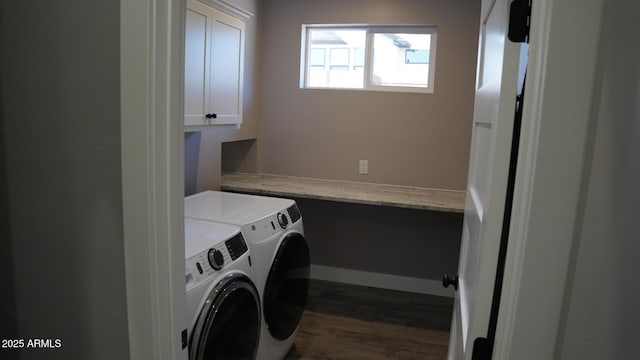 laundry room featuring cabinets, dark hardwood / wood-style floors, and washer and clothes dryer