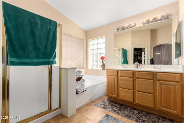 bathroom with a stall shower, tile patterned floors, a sink, a bath, and double vanity