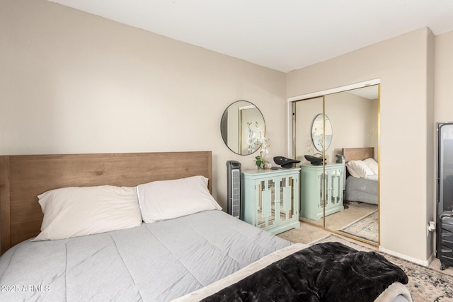 carpeted bedroom with a closet and baseboards