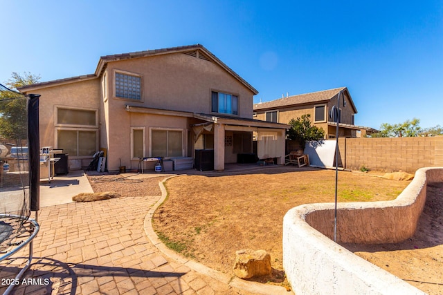 back of house featuring fence, stucco siding, and a patio area