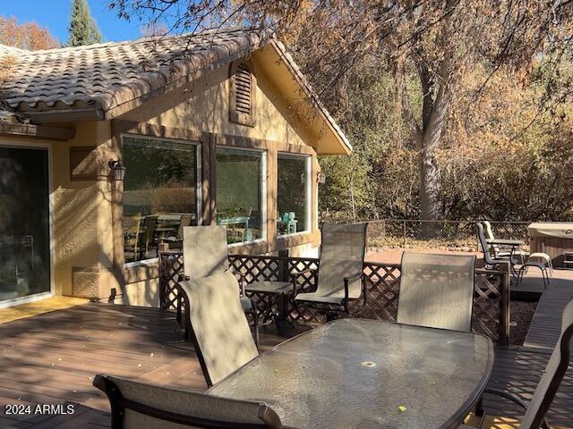 view of patio / terrace featuring a hot tub and a deck