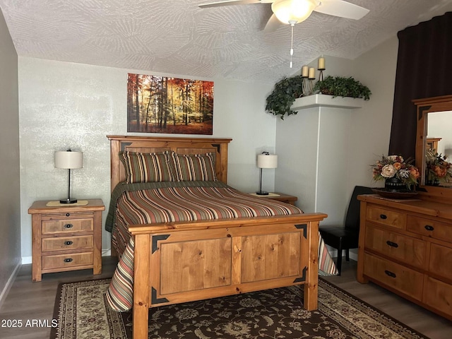 bedroom featuring dark hardwood / wood-style flooring, ceiling fan, and a textured ceiling