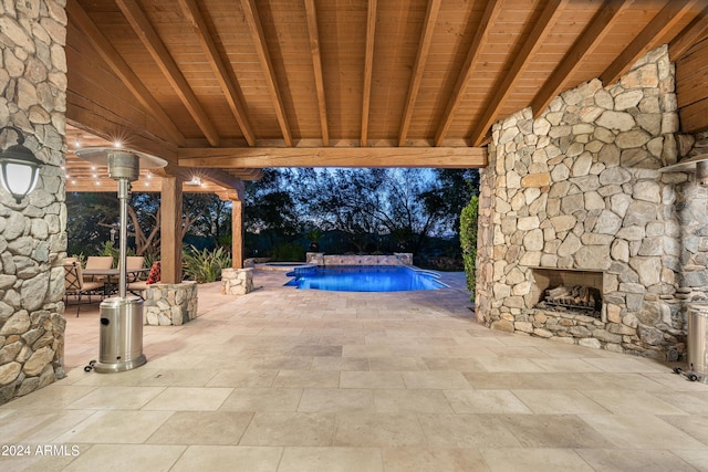 view of patio / terrace with a swimming pool with hot tub and an outdoor stone fireplace