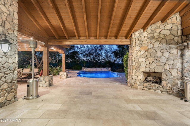 view of patio with an outdoor stone fireplace and an outdoor pool
