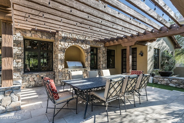 view of patio with exterior kitchen and a pergola