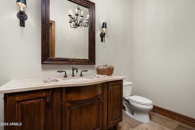 bathroom with an inviting chandelier, vanity, and toilet