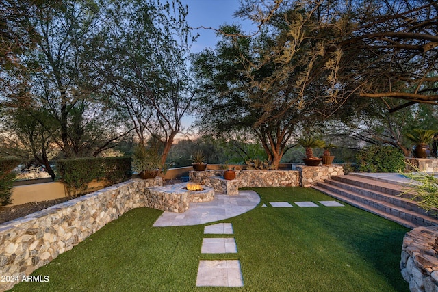 yard at dusk with a patio area and a fire pit