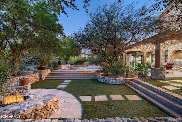 view of yard with a hot tub, a patio, and a fire pit
