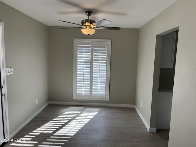 empty room with ceiling fan and dark wood-type flooring