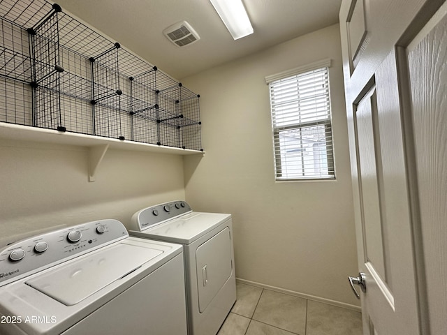 clothes washing area featuring baseboards, washing machine and dryer, light tile patterned flooring, visible vents, and laundry area