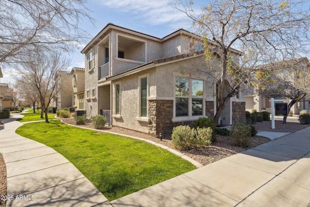 view of side of property featuring stucco siding, stone siding, and a lawn