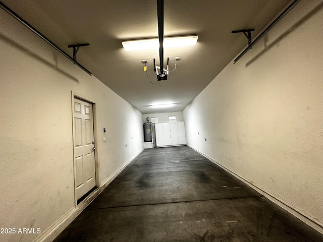 garage featuring electric water heater, baseboards, and a garage door opener