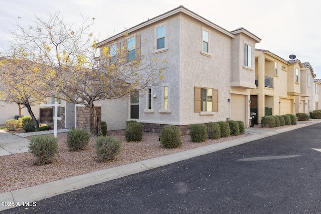 view of front of property with an attached garage, driveway, and stucco siding
