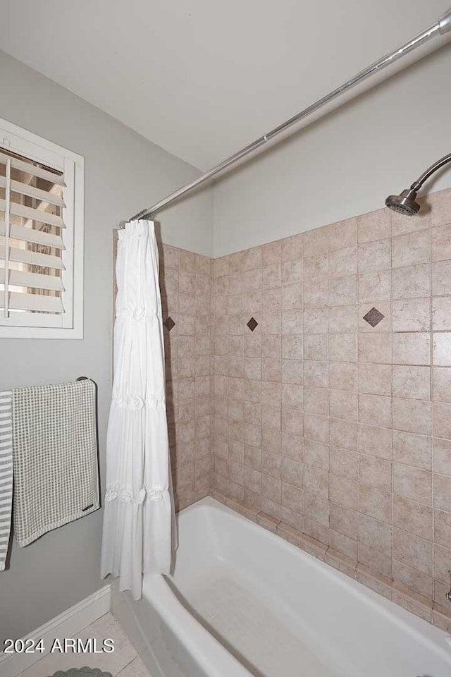 bathroom with tile patterned flooring and shower / bathtub combination with curtain