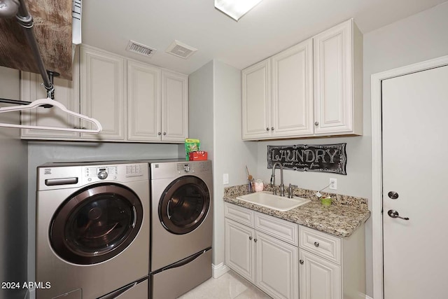 washroom with cabinets, independent washer and dryer, sink, and light tile patterned floors