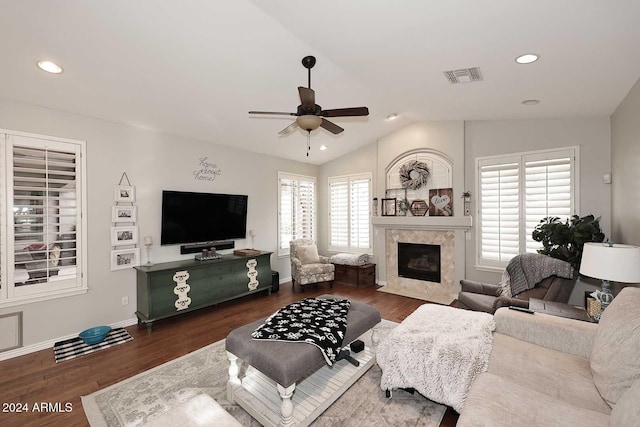 living room with ceiling fan, a high end fireplace, dark hardwood / wood-style floors, and lofted ceiling