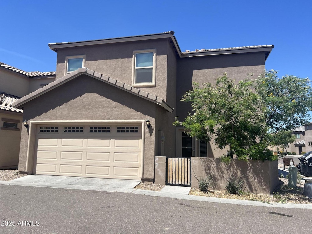 view of property featuring a tile roof, fence, and stucco siding