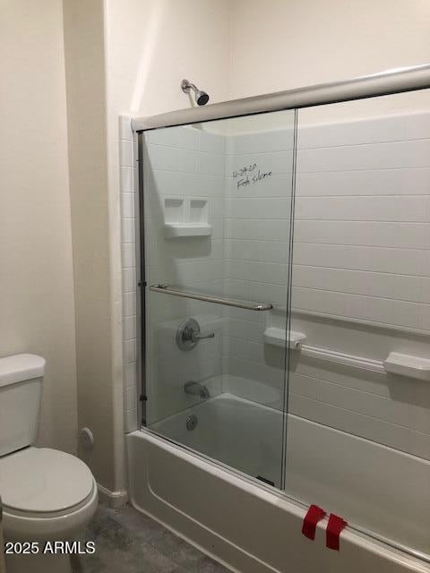 bathroom featuring tile patterned floors, toilet, and combined bath / shower with glass door