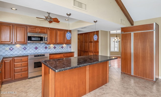 kitchen with tasteful backsplash, stainless steel microwave, visible vents, stove, and brown cabinetry