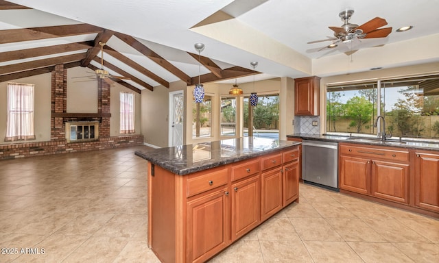 kitchen with a sink, a ceiling fan, stainless steel dishwasher, a brick fireplace, and decorative backsplash