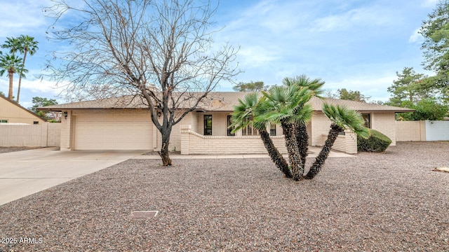 view of front of house with a garage, driveway, brick siding, and fence