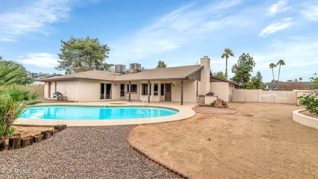 view of swimming pool with central AC unit, a fenced in pool, a gate, fence, and a patio area