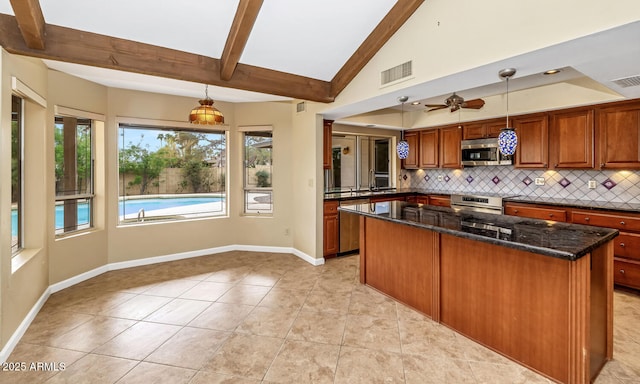 kitchen with brown cabinets, vaulted ceiling with beams, visible vents, stainless steel microwave, and backsplash