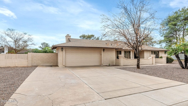 single story home with brick siding, a chimney, fence, a garage, and driveway