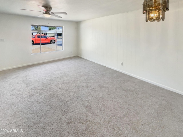 empty room with carpet flooring, baseboards, and a ceiling fan