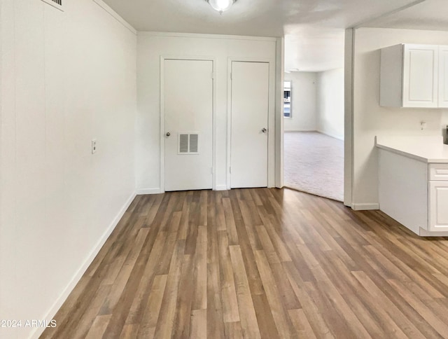 unfurnished dining area with visible vents, baseboards, and wood finished floors
