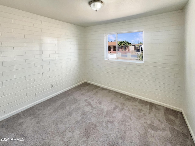 carpeted spare room featuring baseboards