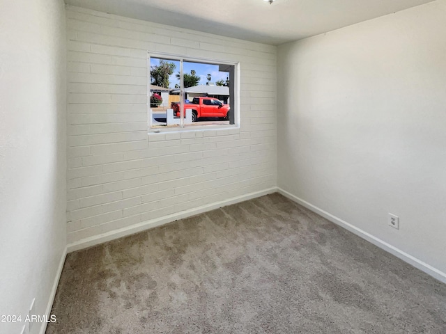 carpeted empty room featuring baseboards