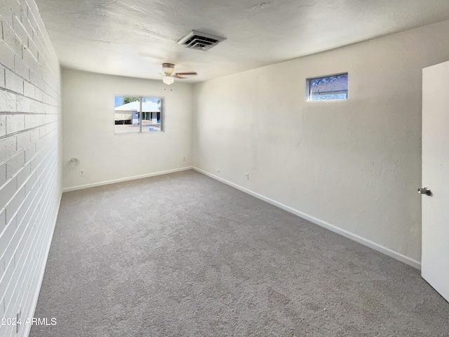 empty room with baseboards, carpet flooring, ceiling fan, and visible vents