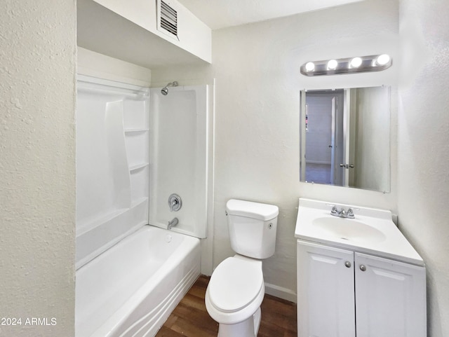 full bathroom featuring hardwood / wood-style floors, vanity, washtub / shower combination, and toilet