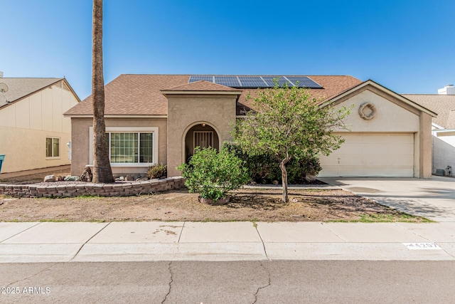 4207 W Soft Wind Dr, Glendale, AZ 85310 - view of front of house featuring stucco siding, a garage, roof mounted solar panels, driveway, and a shingled roof