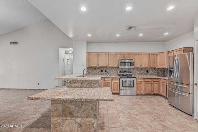 4207 W Soft Wind Dr, Glendale, AZ 85310 - kitchen featuring appliances with stainless steel finishes, a peninsula, decorative backsplash, recessed lighting, and light stone counters