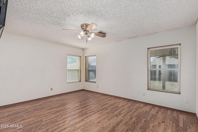 4207 W Soft Wind Dr, Glendale, AZ 85310 - empty room with wood finished floors, ceiling fan, plenty of natural light, and a textured ceiling