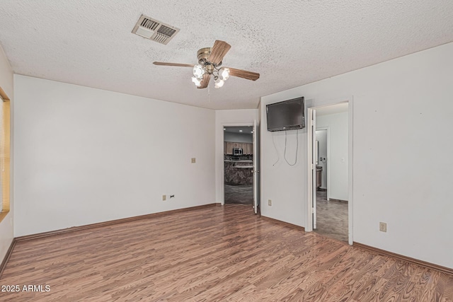 4207 W Soft Wind Dr, Glendale, AZ 85310 - unfurnished bedroom with wood finished floors, a textured ceiling, baseboards, and ceiling fan