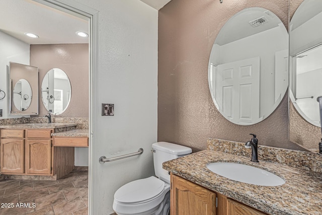 4207 W Soft Wind Dr, Glendale, AZ 85310 - bathroom with toilet, a textured wall, and two vanities
