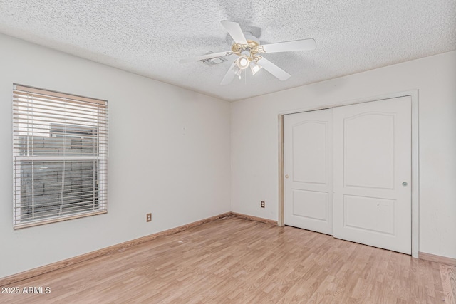4207 W Soft Wind Dr, Glendale, AZ 85310 - unfurnished bedroom with light wood-type flooring, a textured ceiling, a closet, baseboards, and a ceiling fan