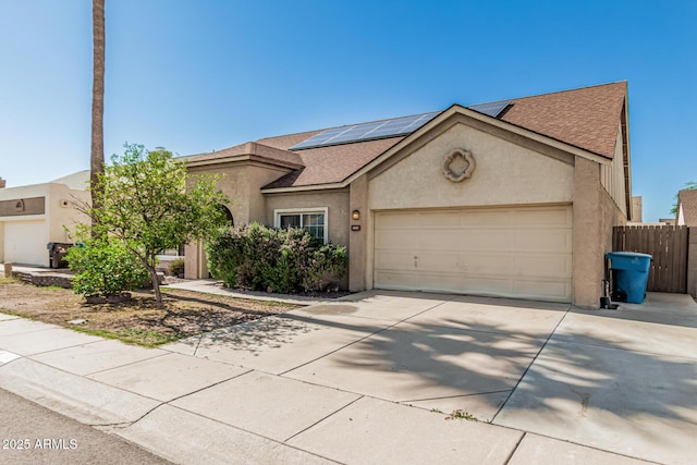 4207 W Soft Wind Dr, Glendale, AZ 85310 - view of front facade with driveway, stucco siding, roof mounted solar panels, an attached garage, and roof with shingles