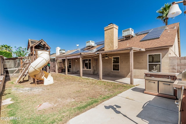4207 W Soft Wind Dr, Glendale, AZ 85310 - rear view of house with roof with shingles, a playground, a chimney, a fenced backyard, and central air condition unit
