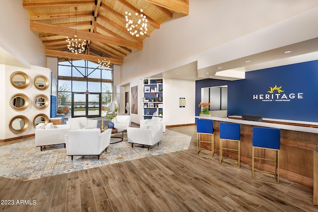 living room featuring hardwood / wood-style flooring, beam ceiling, high vaulted ceiling, a chandelier, and wooden ceiling