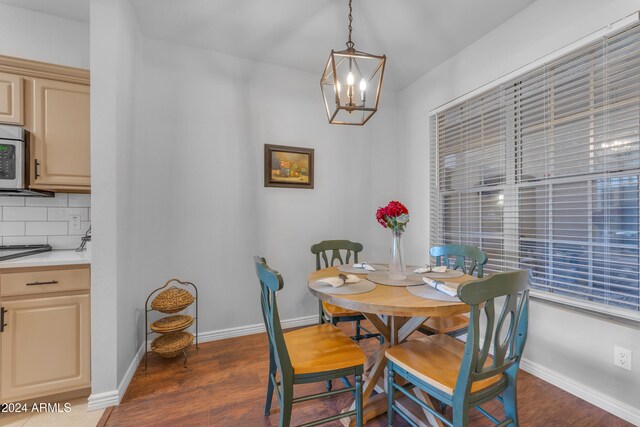 dining room featuring dark wood-type flooring and an inviting chandelier