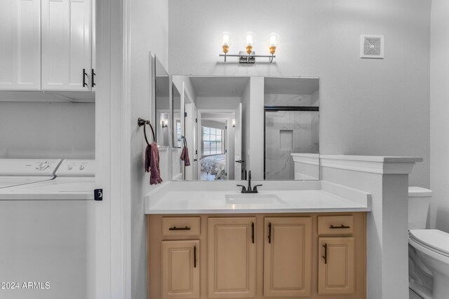 bathroom with walk in shower, vanity, toilet, and washing machine and clothes dryer