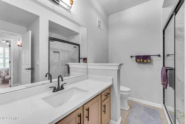 bathroom featuring walk in shower, toilet, vanity, and tile patterned floors