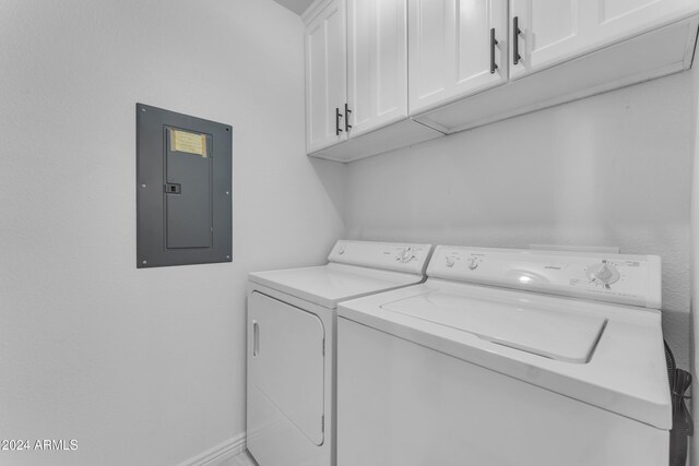 laundry area with electric panel, cabinets, and washing machine and clothes dryer