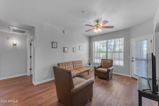 living room with ceiling fan and dark hardwood / wood-style flooring