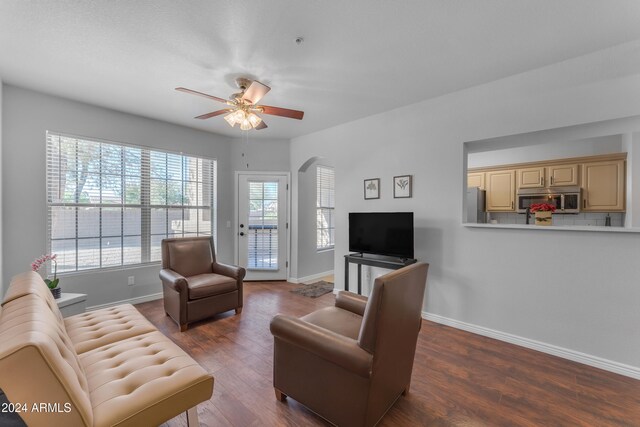 living room with dark wood-type flooring and ceiling fan