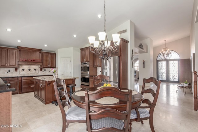 dining area featuring vaulted ceiling, a chandelier, and french doors